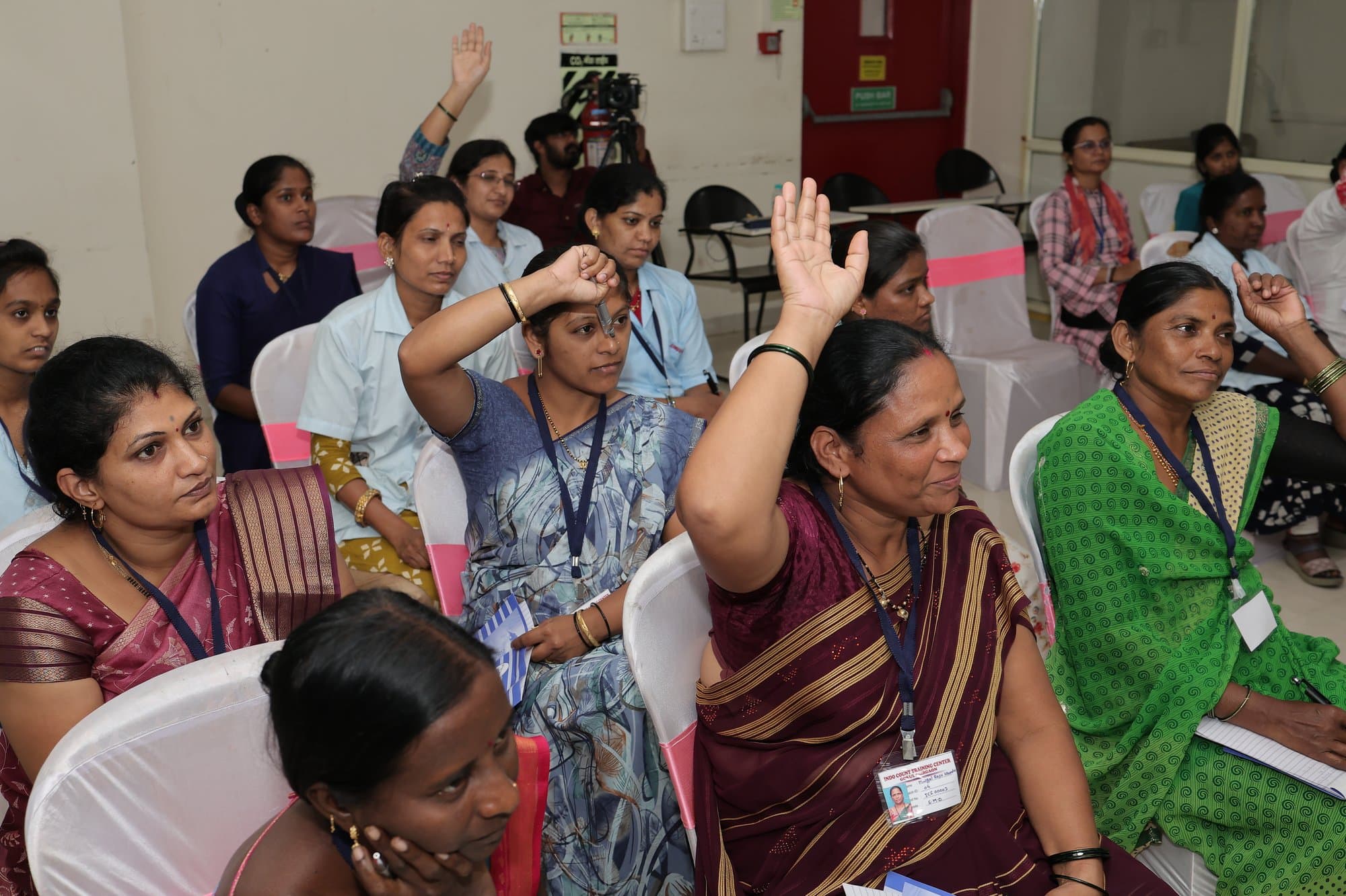 Participants raising their hands during a session in Kolhapur